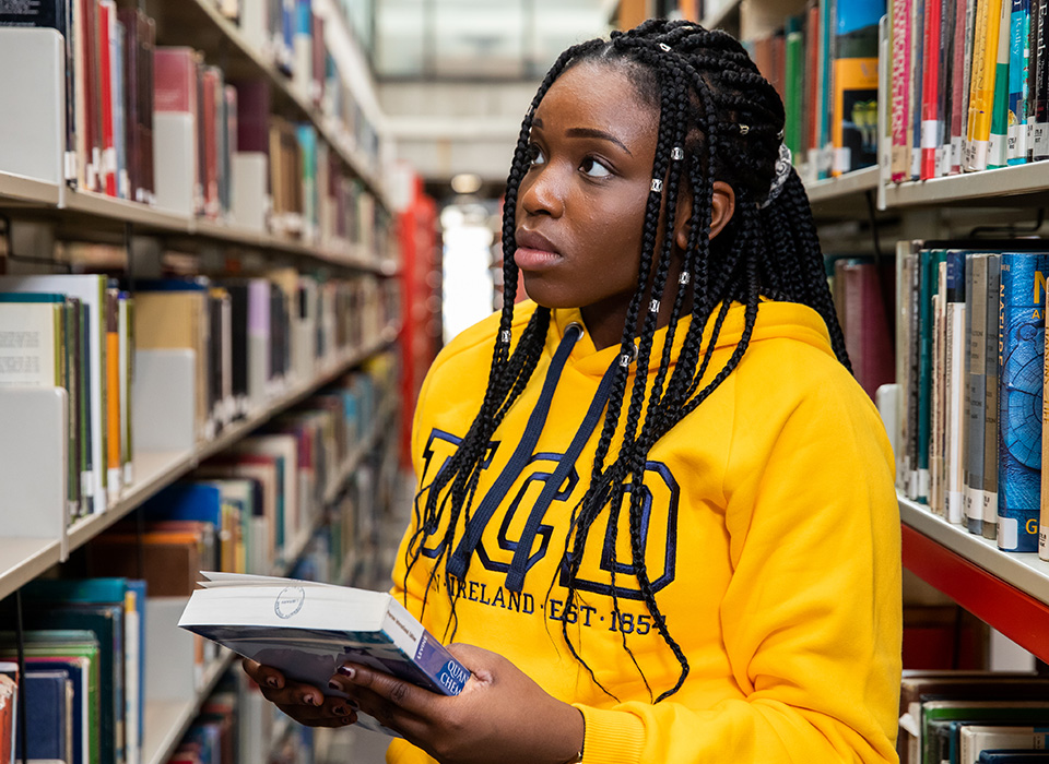 Woman in library holding a book